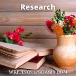 Image of flowers in vase and book and title which is research.