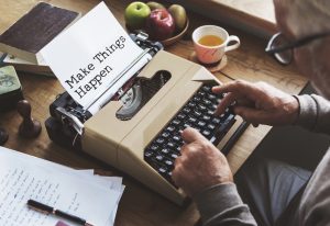 Image of man typing on retro typewriter.